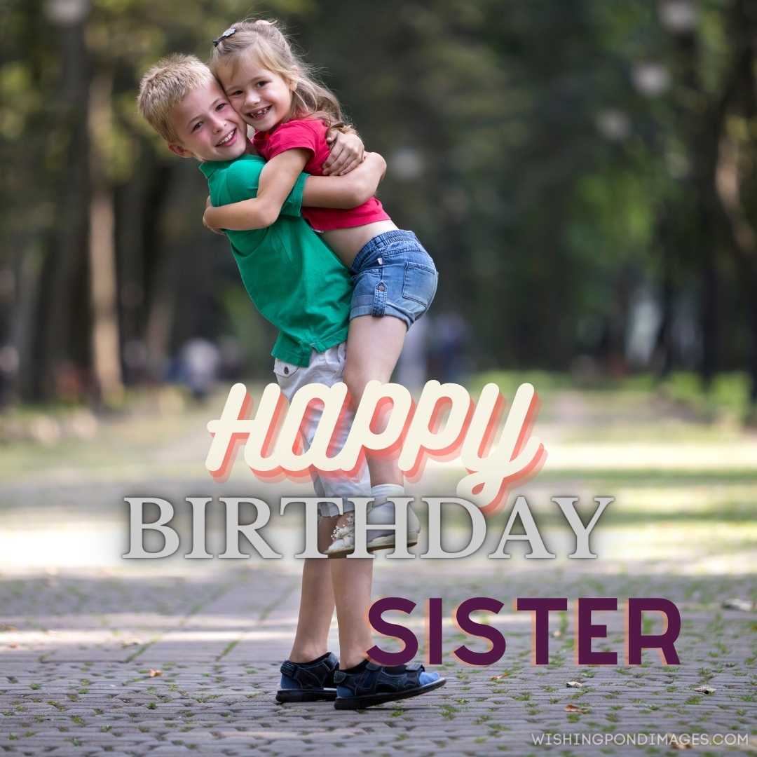 Brother holding sister in his arms, having fun on a blurred bright sunny day. Happy Birthday Sister 